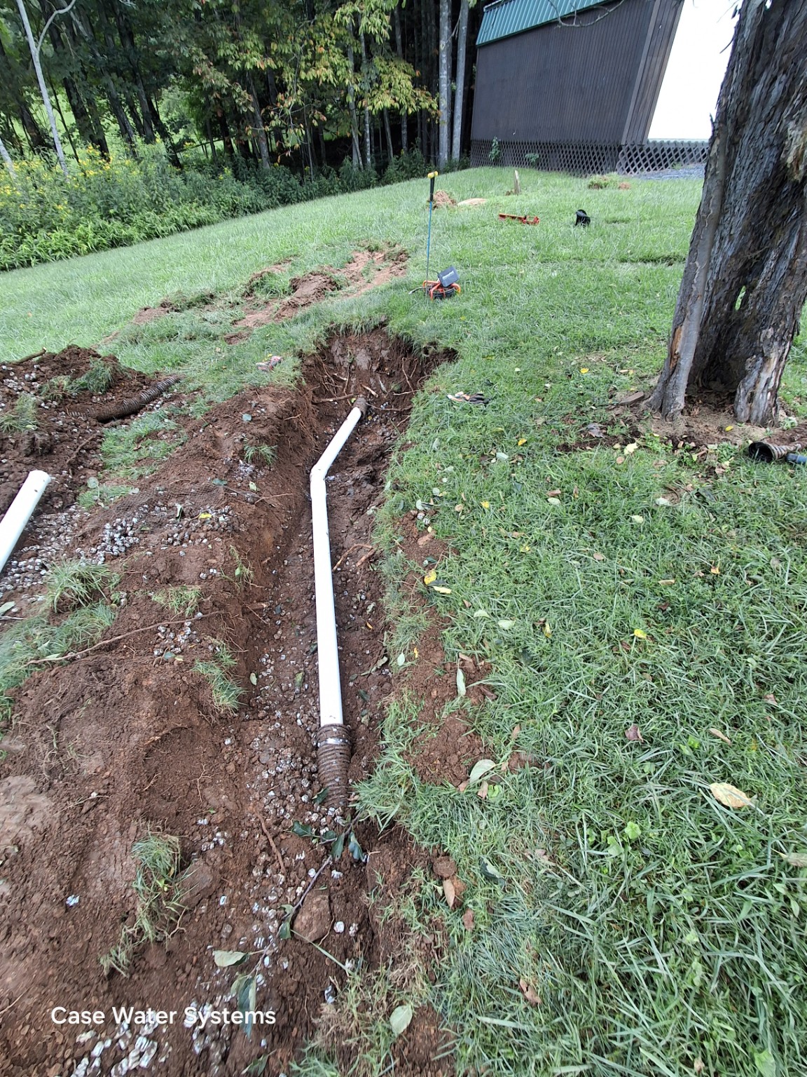 Underground pipes laid in a lawn trench.