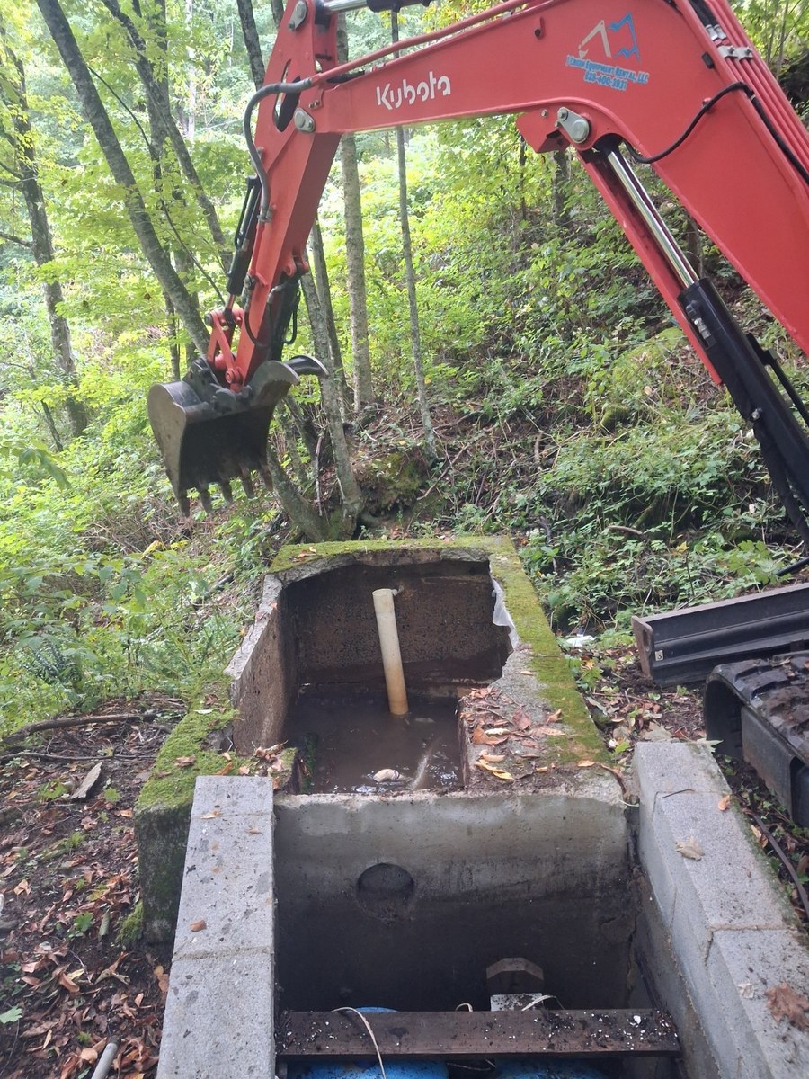 Excavation around a concrete spring collection box.