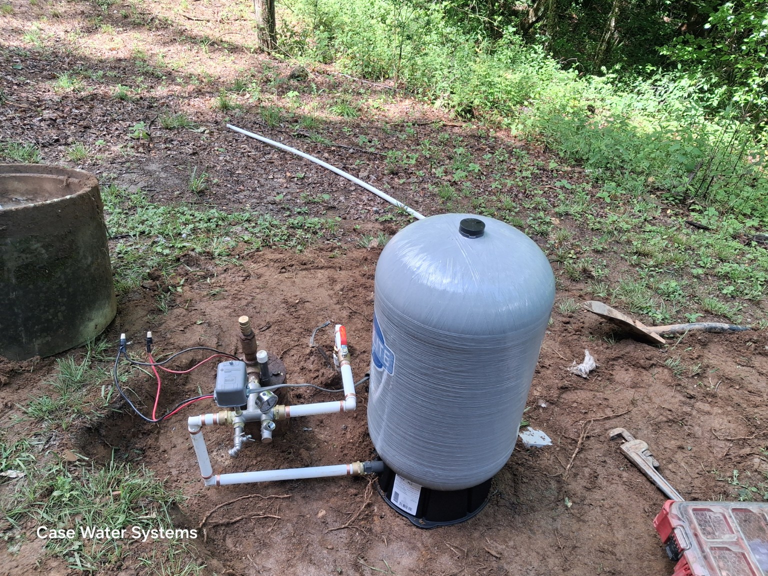 Outdoor well pressure tank with pressure switch, gauge and connected plumbing